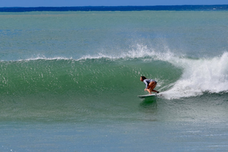 lone teen girl surfs long wave
